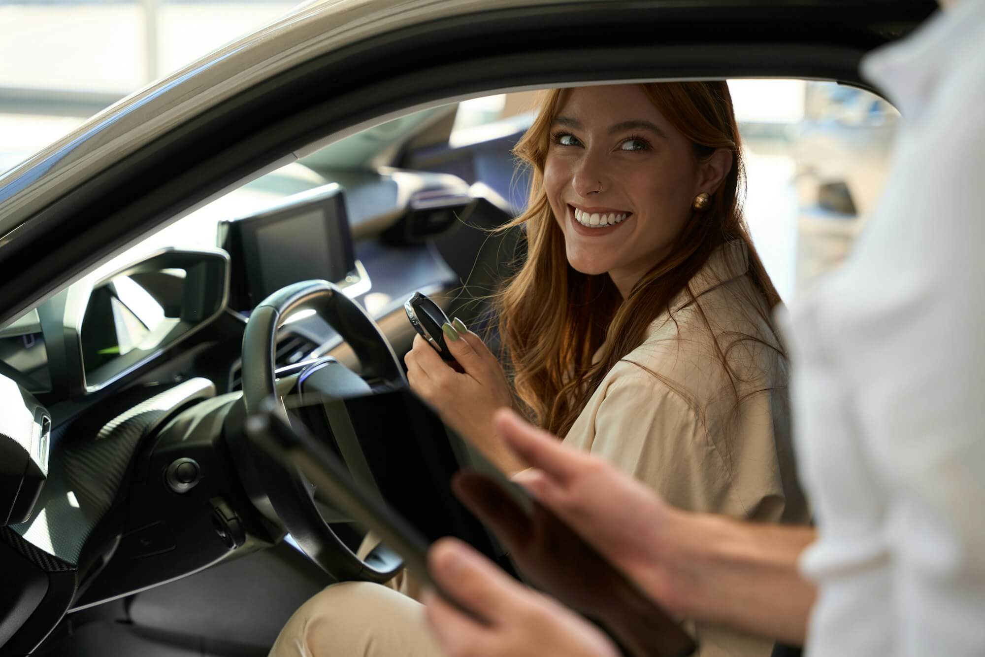 auto-dealership-customer-seated-in-motorcar-talking-to-sales-consultant.jpg